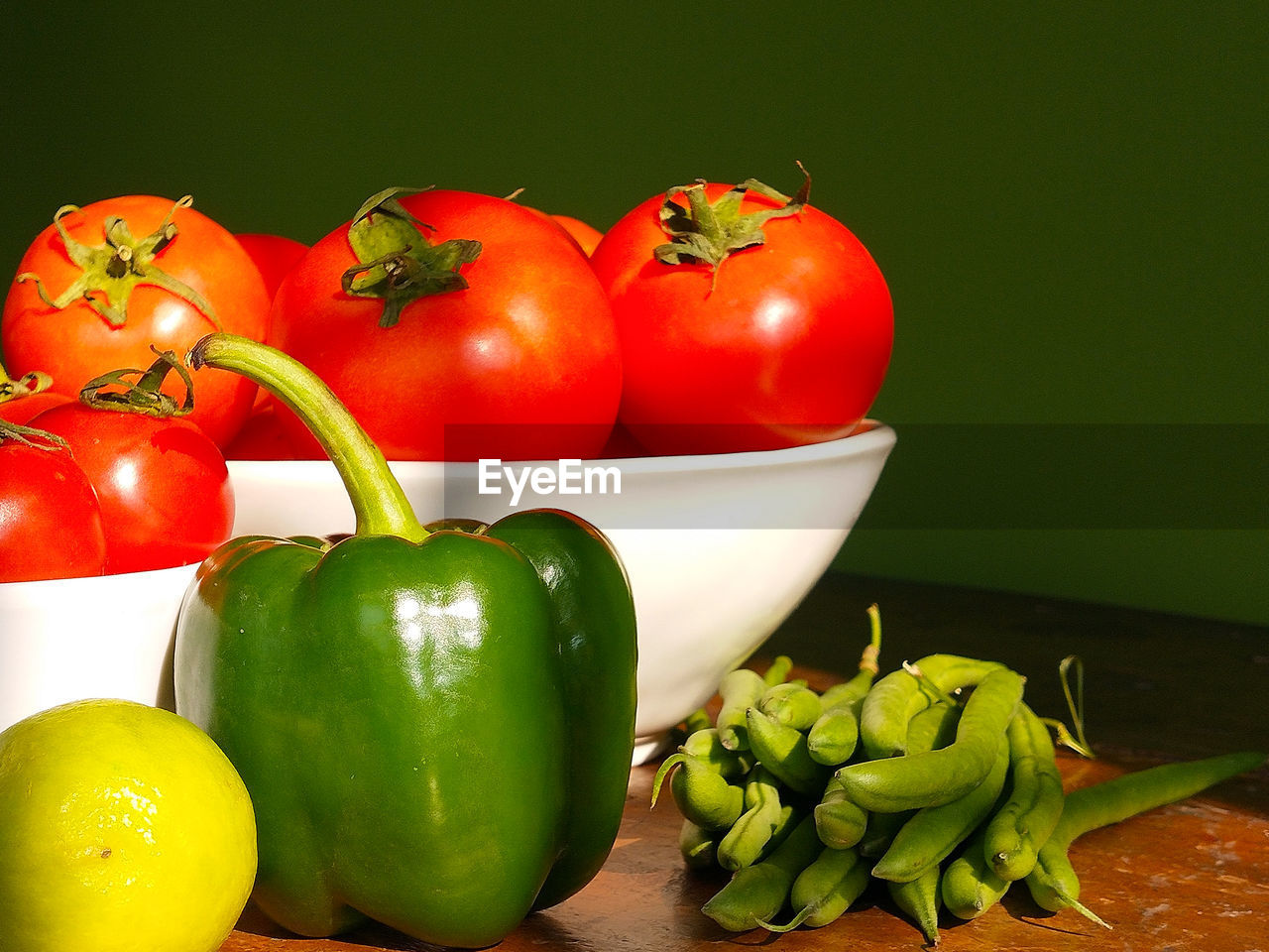 Close-up of tomatoes and green vegetables on table