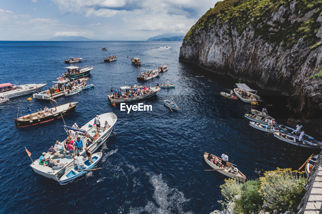 HIGH ANGLE VIEW OF PEOPLE ON BOAT IN SEA