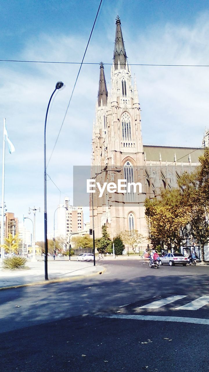 Street light on road against church in city