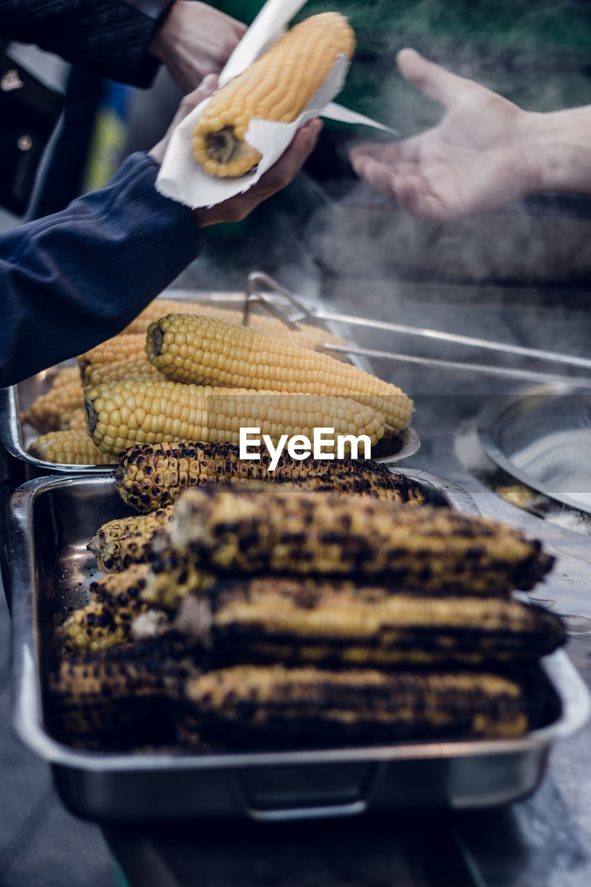 Roasted corn cobs in container for sale