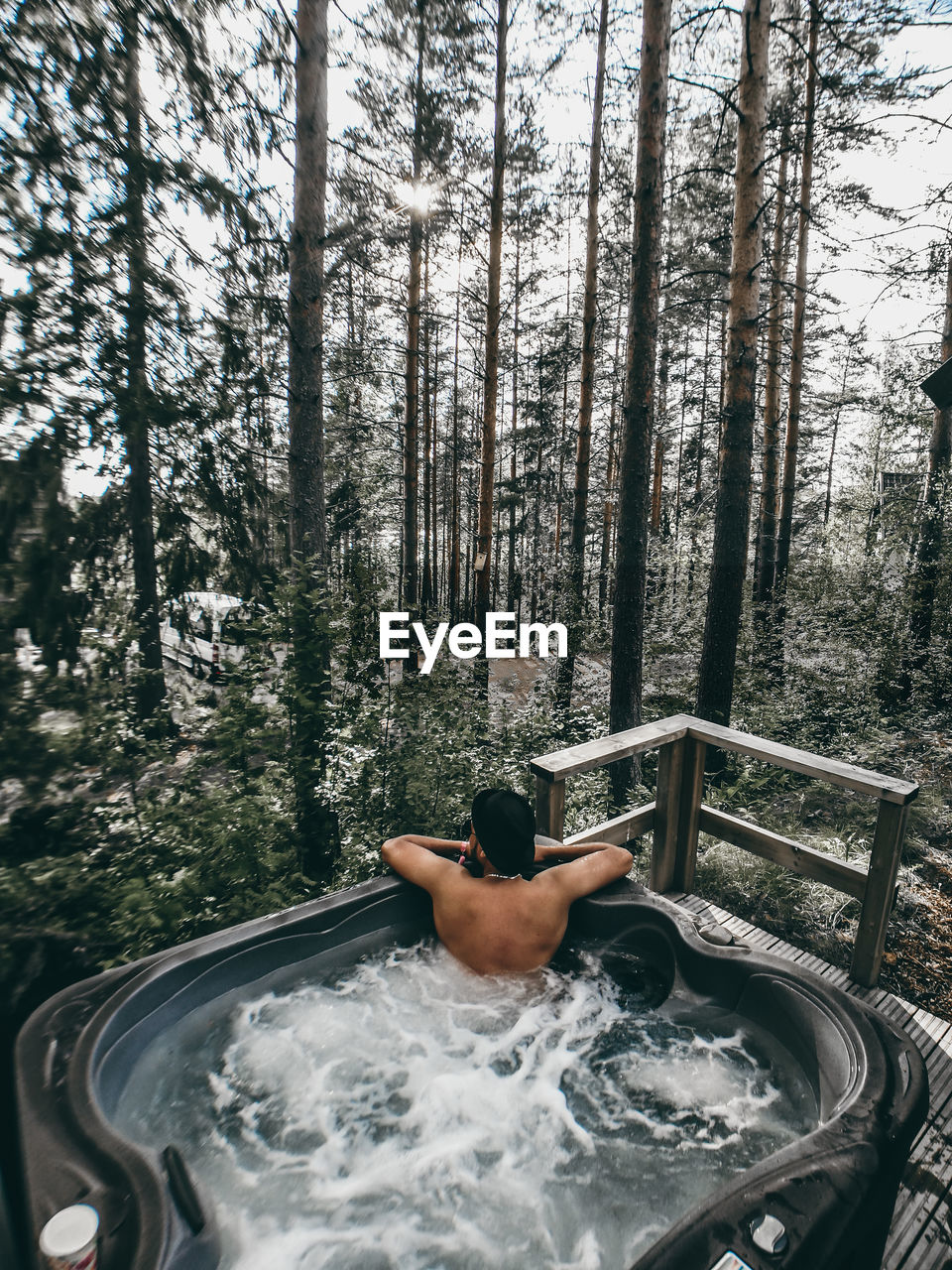 High angle view of shirtless man in hot tub against trees