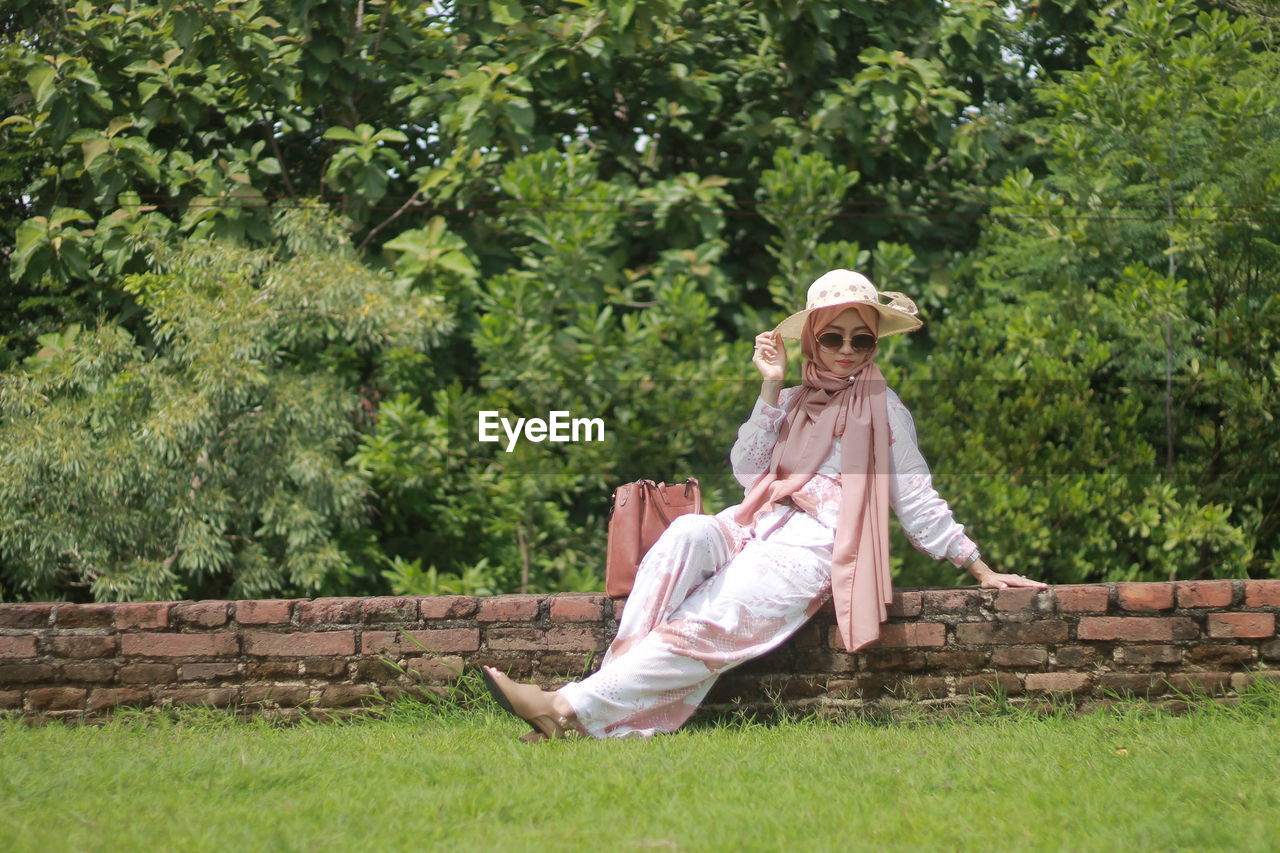 Woman sitting on bench in park