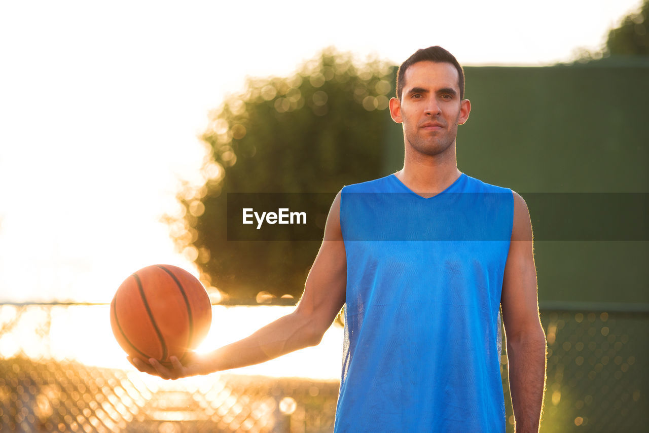 YOUNG MAN WITH BALL IN BACKGROUND