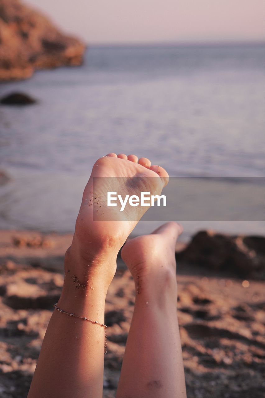 Low section of person relaxing on beach