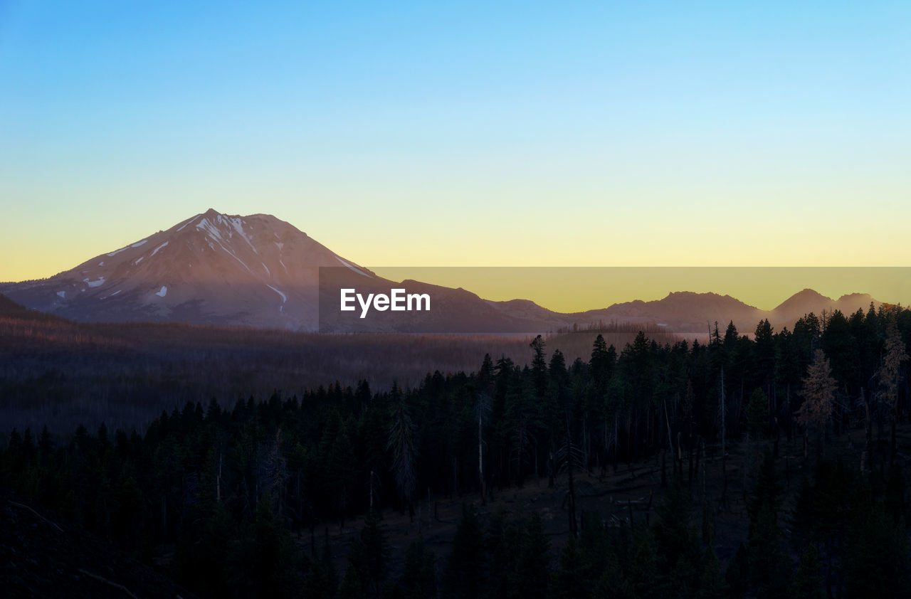 Scenic view of mountains against clear sky during sunset