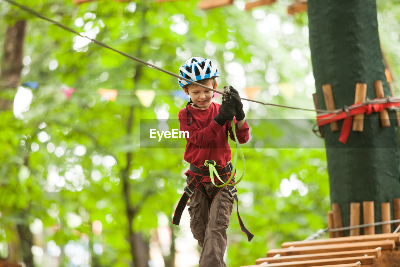 MAN HOLDING ROPE TIED TO TREE