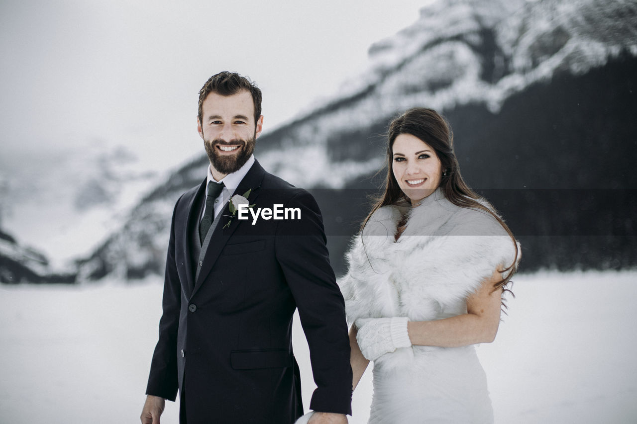 Caucasian couple in wedding attire just married in winter in mountains