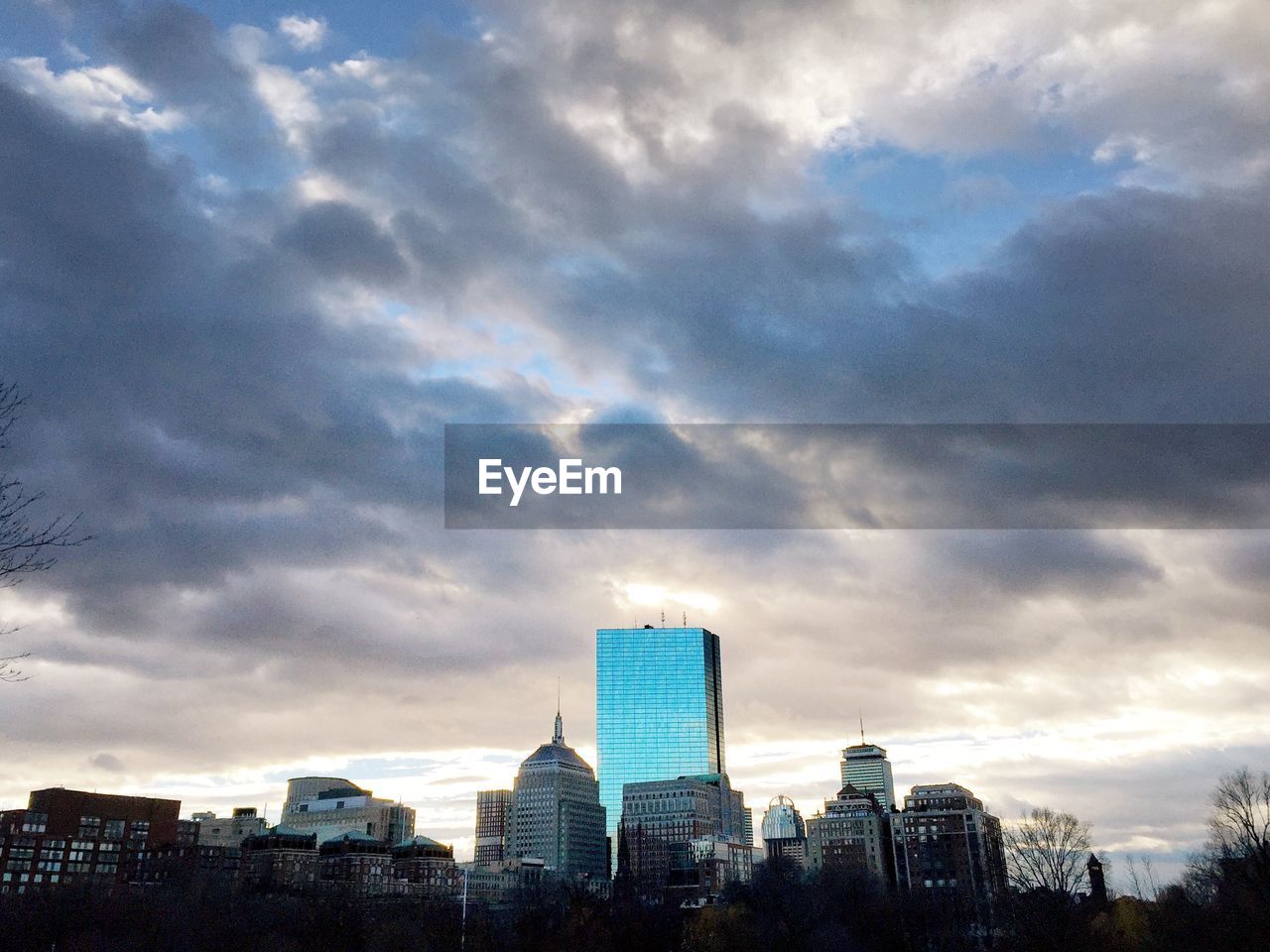 LOW ANGLE VIEW OF MODERN BUILDINGS AGAINST CLOUDY SKY