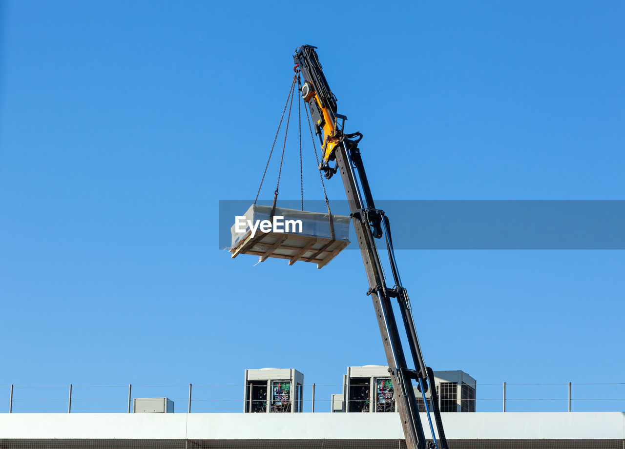 sky, crane - construction machinery, clear sky, industry, machinery, blue, architecture, construction equipment, mast, copy space, construction industry, sunny, nature, day, built structure, business, no people, vehicle, low angle view, construction site, development, freight transportation, outdoors, business finance and industry, construction machinery, equipment, unloading, sunlight