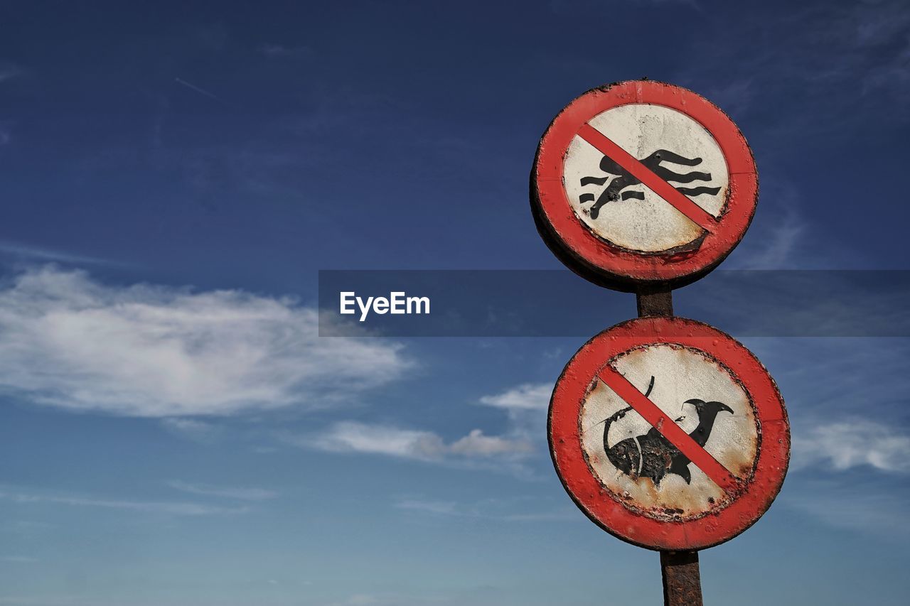 Low angle view of road sign against sky