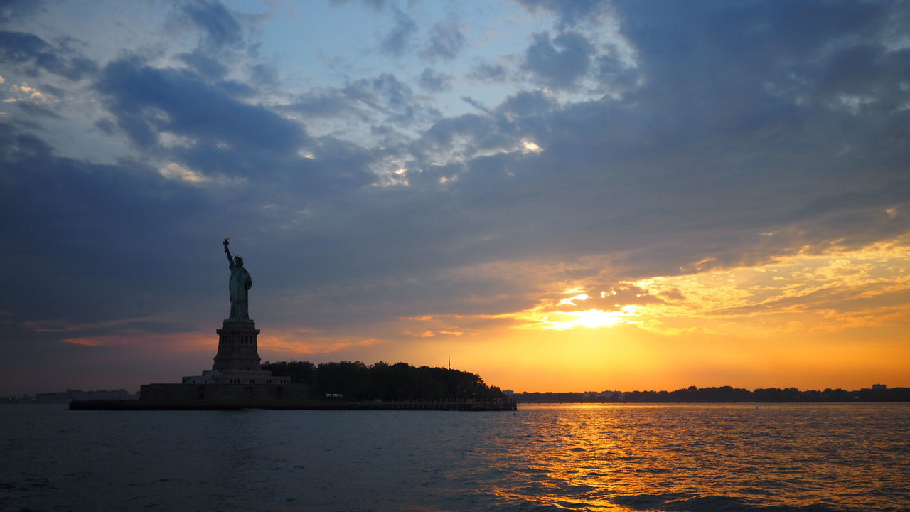 Statue of liberty against sky with waterfront