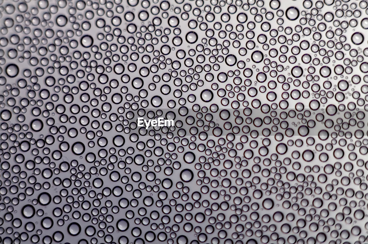 FULL FRAME SHOT OF WATER DROPS ON METAL AGAINST METALLIC STRUCTURE