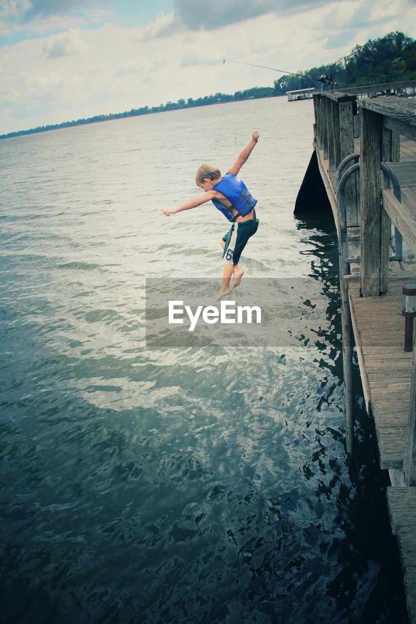 YOUNG WOMAN JUMPING IN WATER