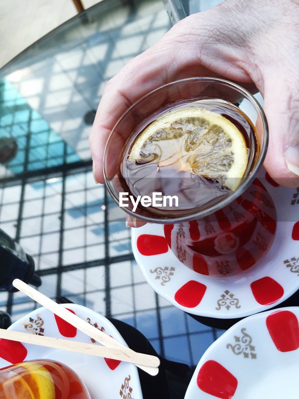 Cropped hand of man having tea at table