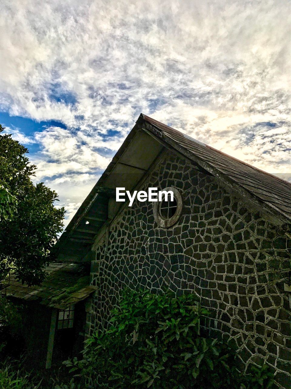 LOW ANGLE VIEW OF BUILDING AGAINST CLOUDS