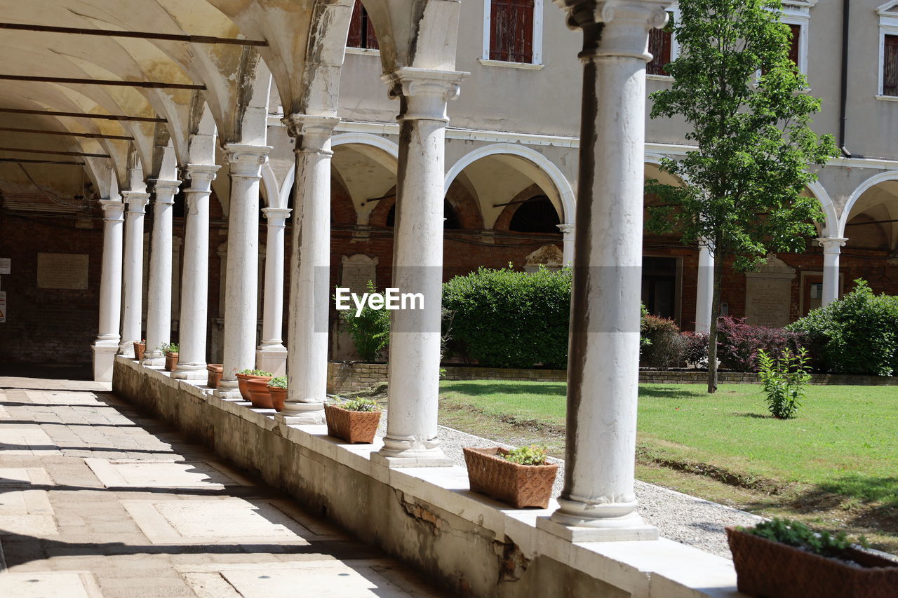 architecture, built structure, architectural column, courtyard, building exterior, building, plant, estate, arch, nature, no people, day, history, the past, outdoors, tree, hacienda, sunlight, column, residential district, palace, travel destinations, mansion, colonnade, grass, house