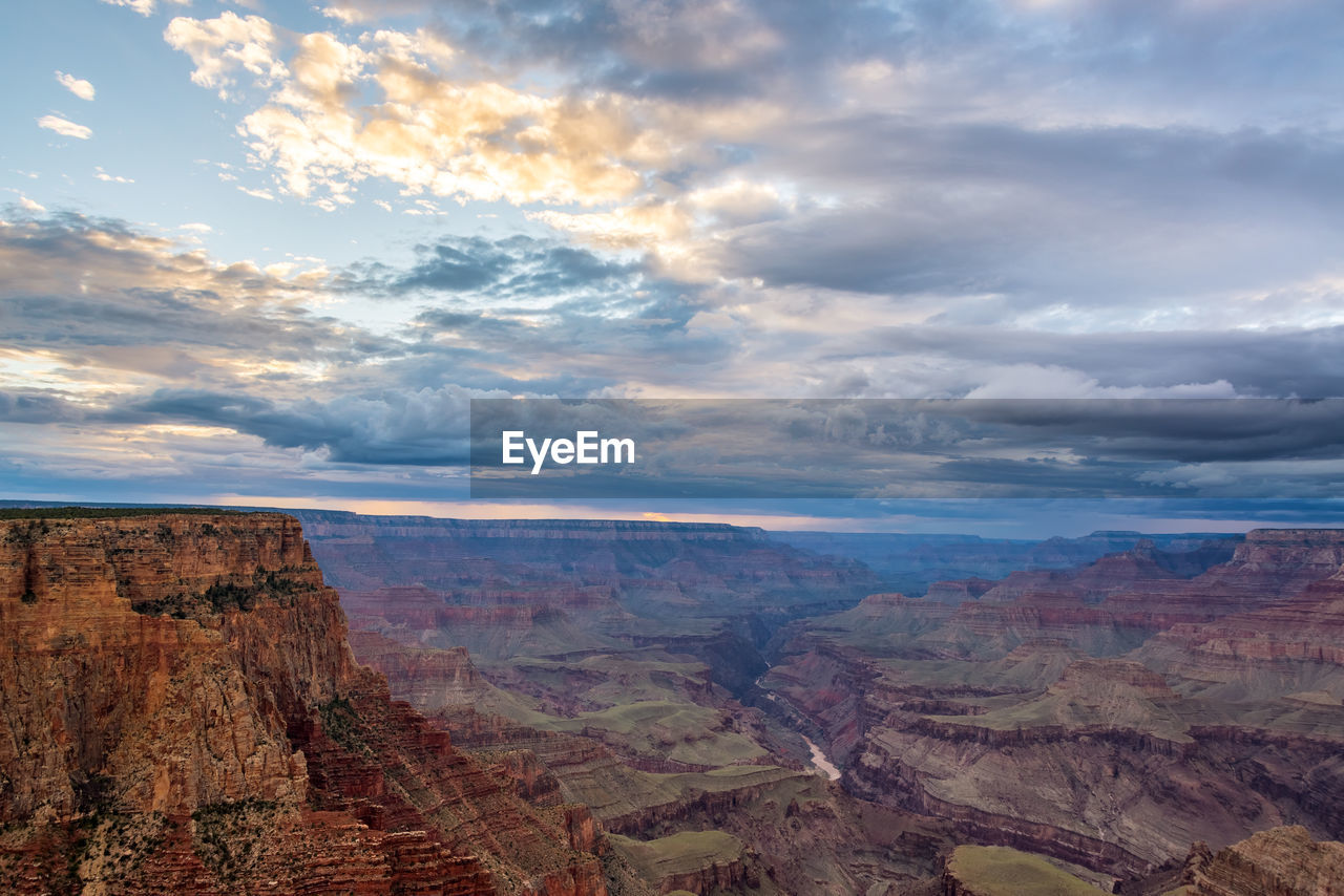 Scenic view of eroded landscape at grand canyon national park against cloudy sky