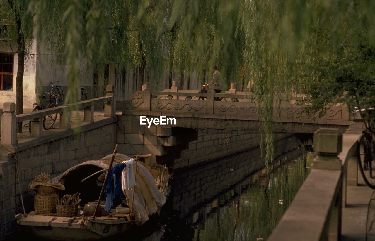 Boat in canal against footbridge