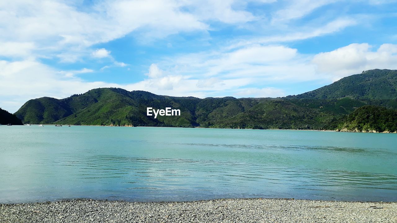 SCENIC VIEW OF LAKE BY MOUNTAIN AGAINST SKY