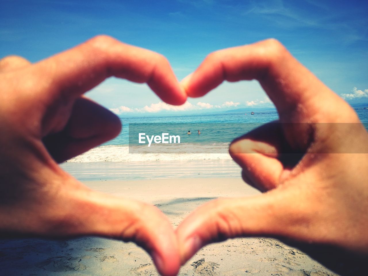 CROPPED IMAGE OF HANDS HOLDING HEART SHAPE ON BEACH