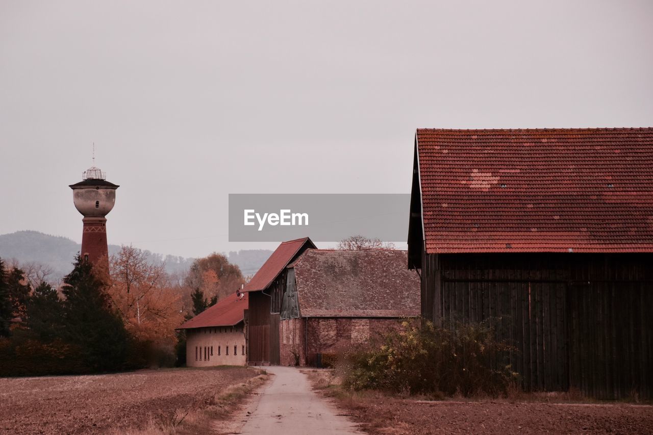 Old house by building against sky