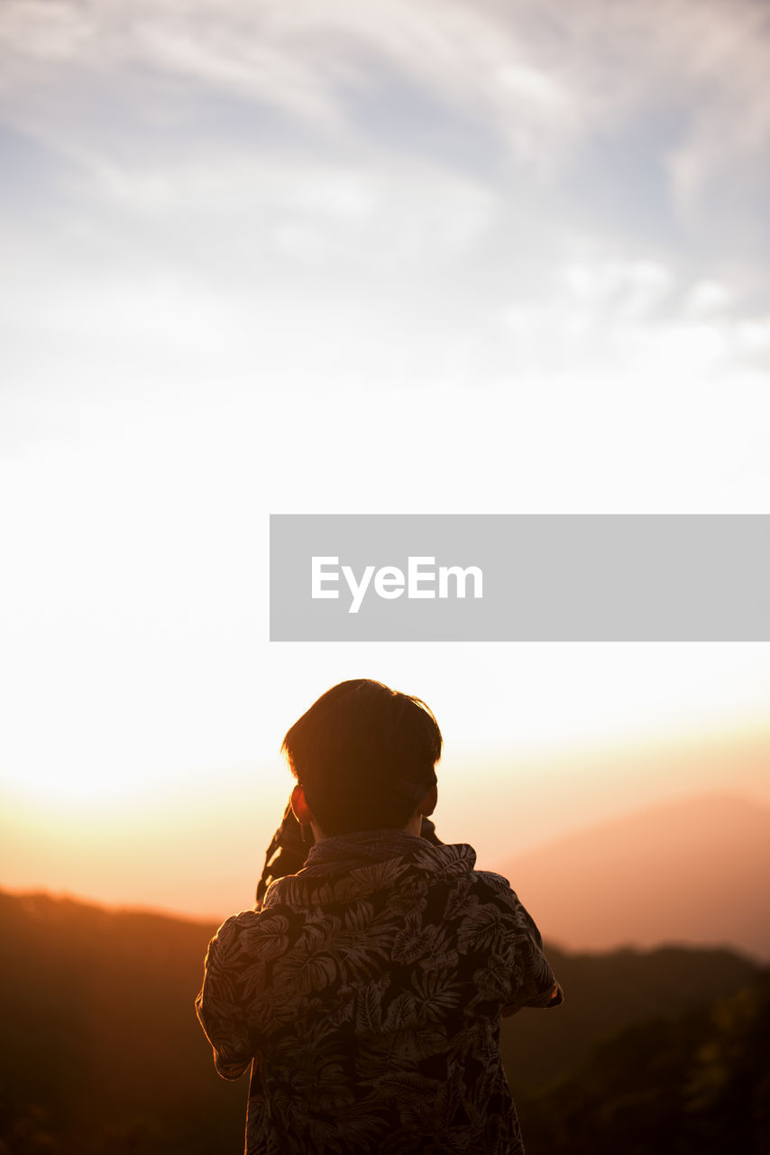 Rear view of man looking at sunset