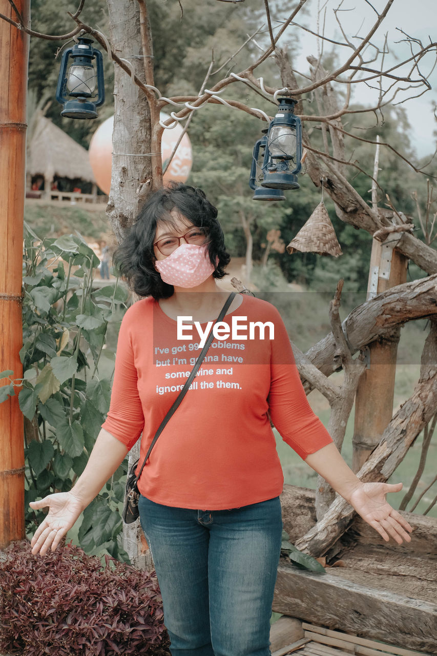 Portrait of woman wearing mask standing outdoors