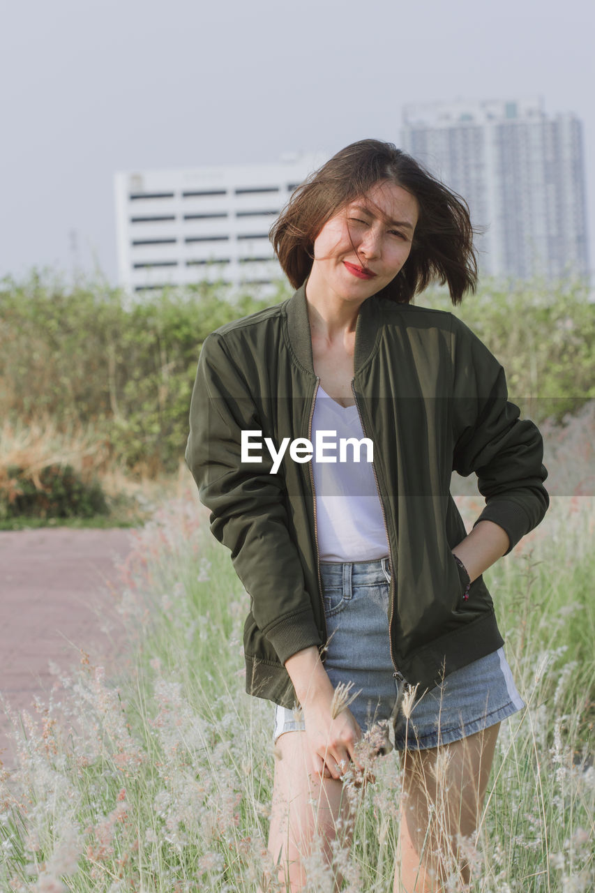 Portrait of woman standing by plants