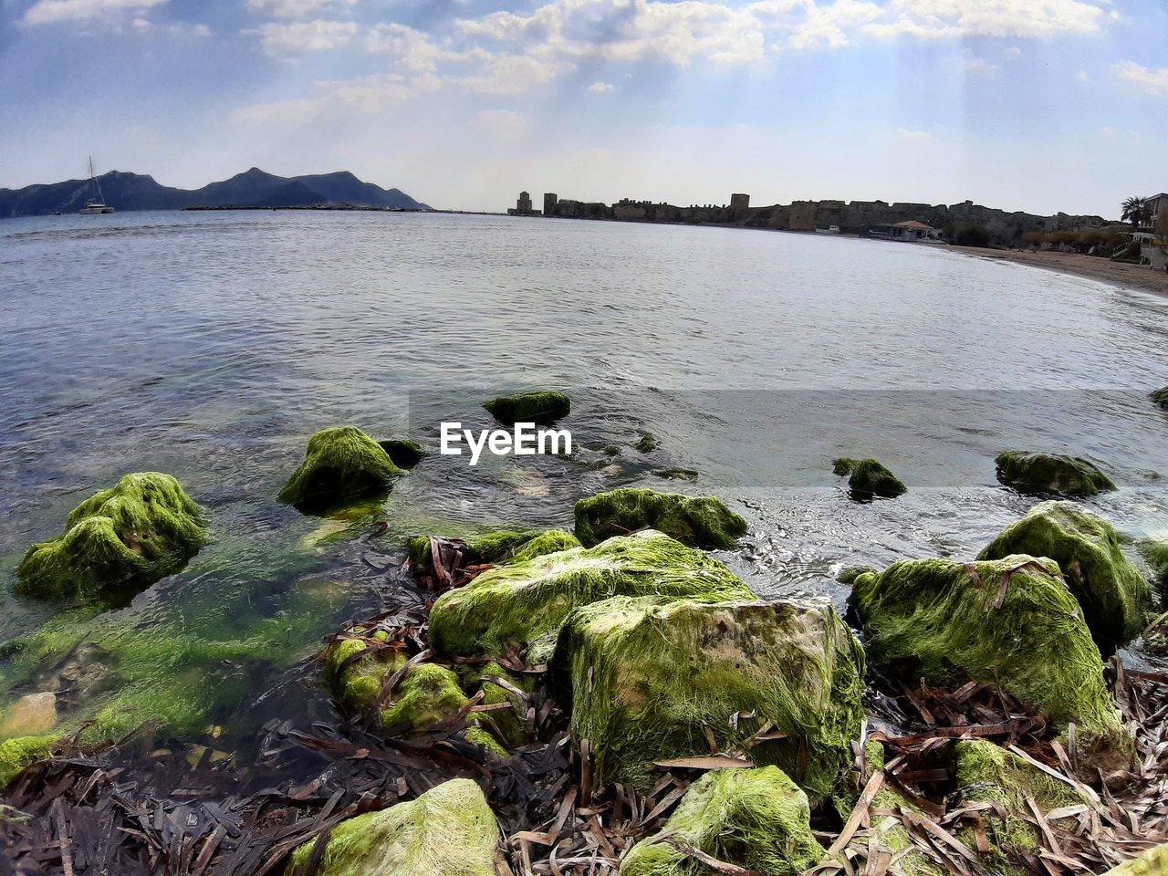 SCENIC VIEW OF SEA BY ROCKS AGAINST SKY