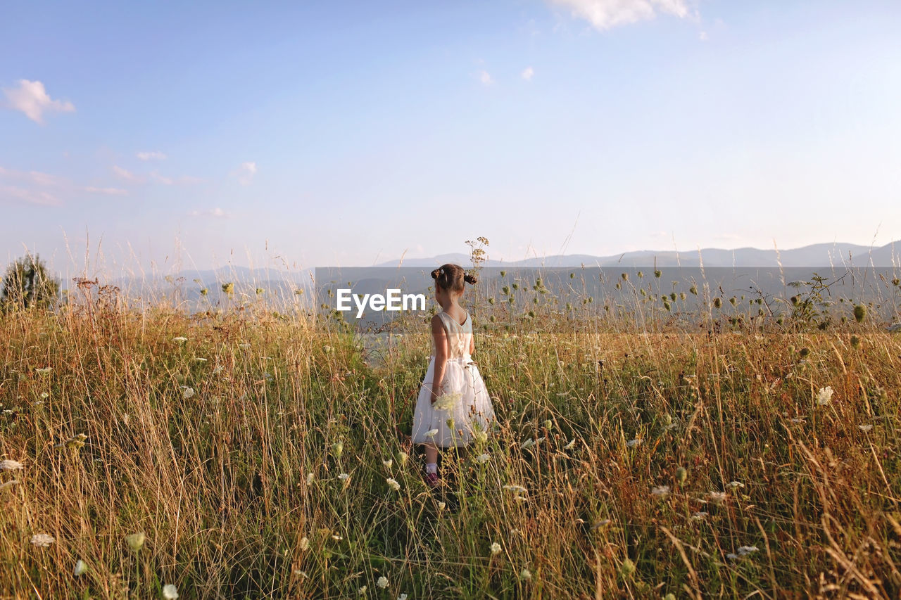 Woman on field against sky