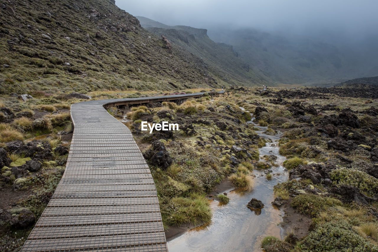 Footbridge on mountains during foggy weather