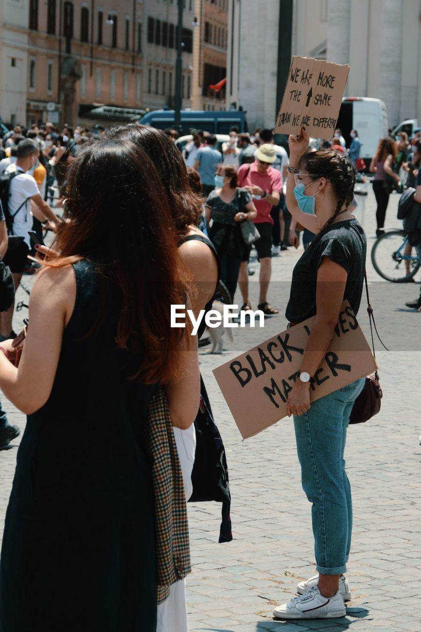 REAR VIEW OF WOMEN WALKING ON STREET