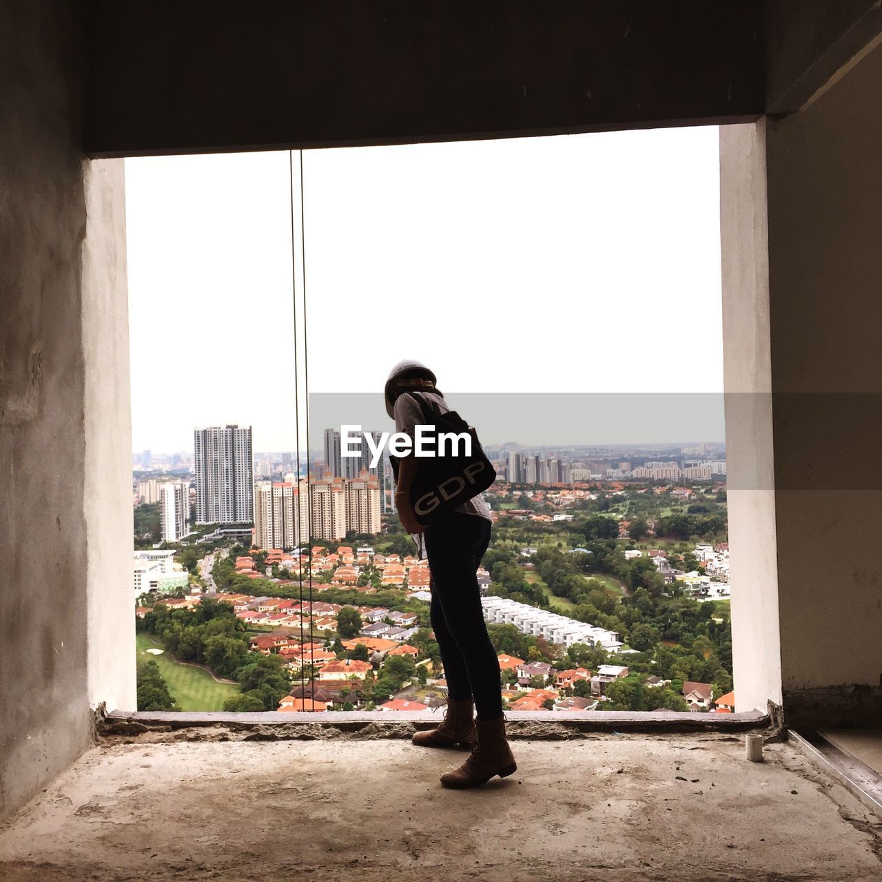 Woman looking down from window in incomplete building