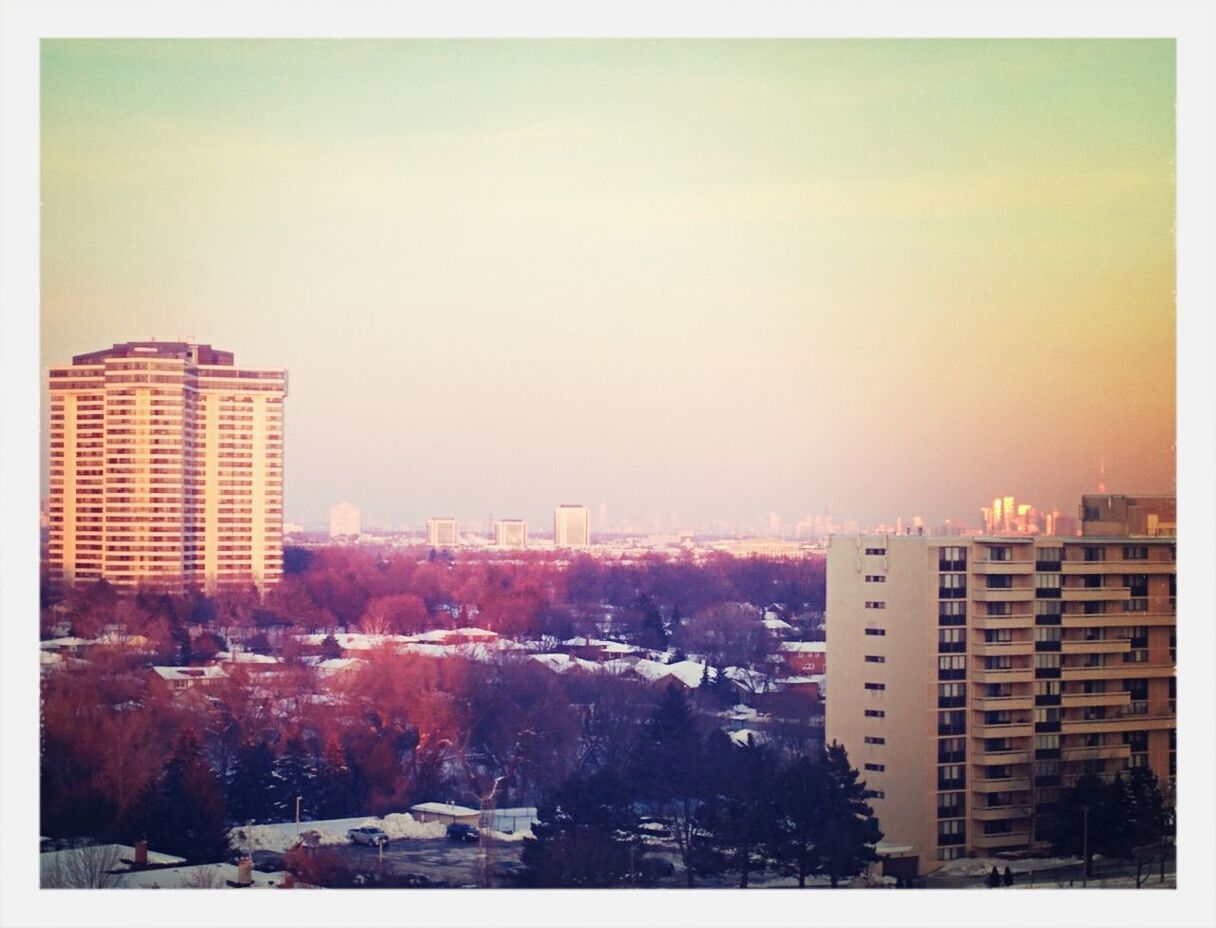 View of trees and buildings against sky during sunset