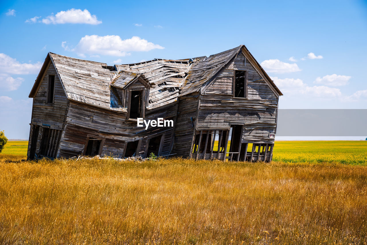 Abandoned building on field against sky