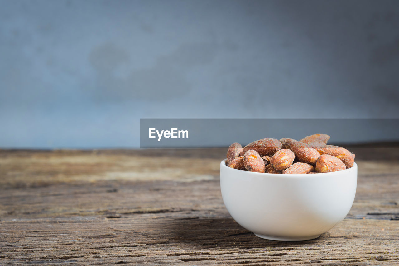 Close-up of salted almonds in bowl on table