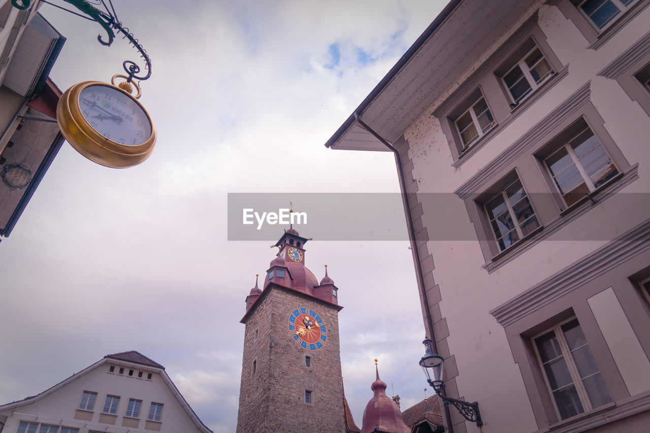 Low angle view of clock tower amidst buildings in city