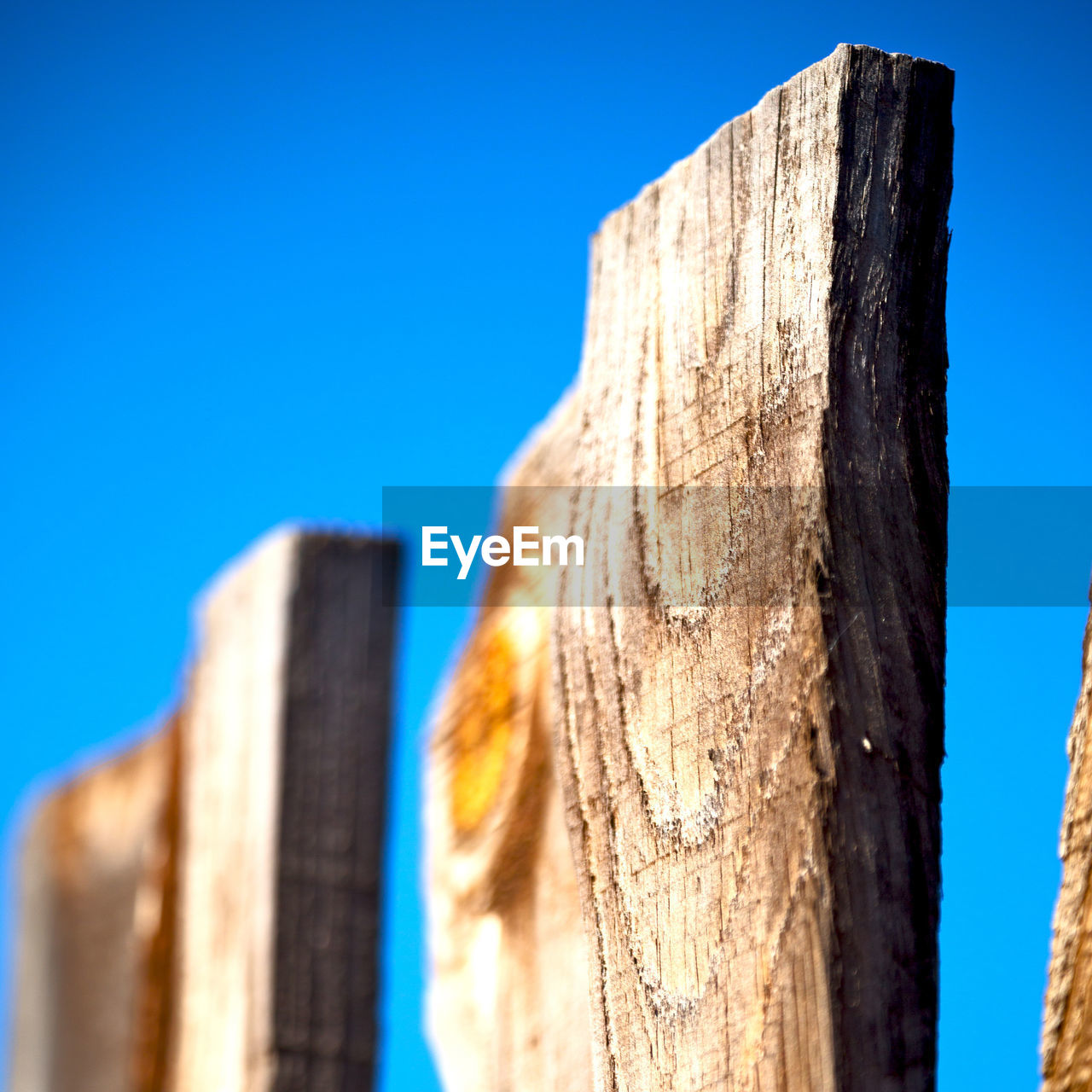 LOW ANGLE VIEW OF WOODEN POST AGAINST SKY