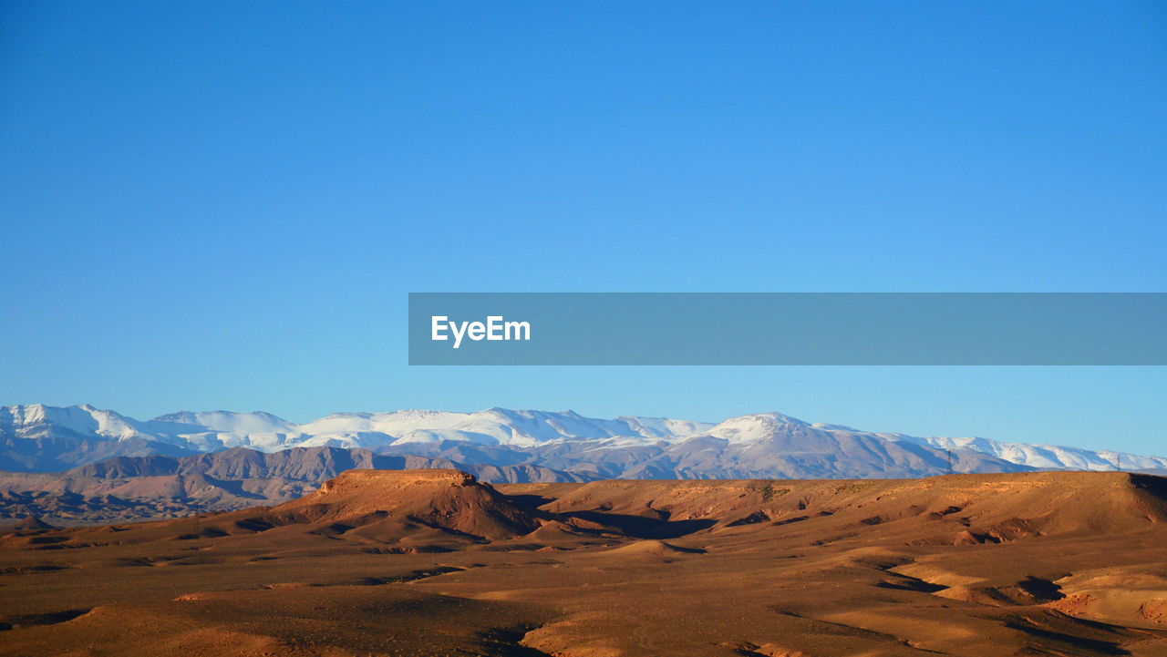 Scenic view of mountains against clear blue sky