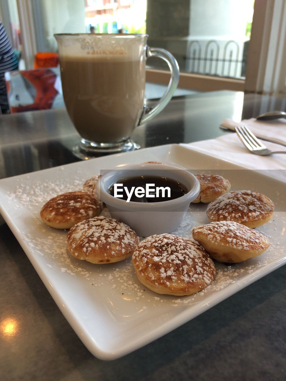 Sweet food in plate by glass of drink on table at restaurant