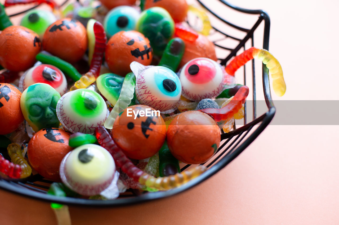 HIGH ANGLE VIEW OF MULTI COLORED CANDIES IN CONTAINER