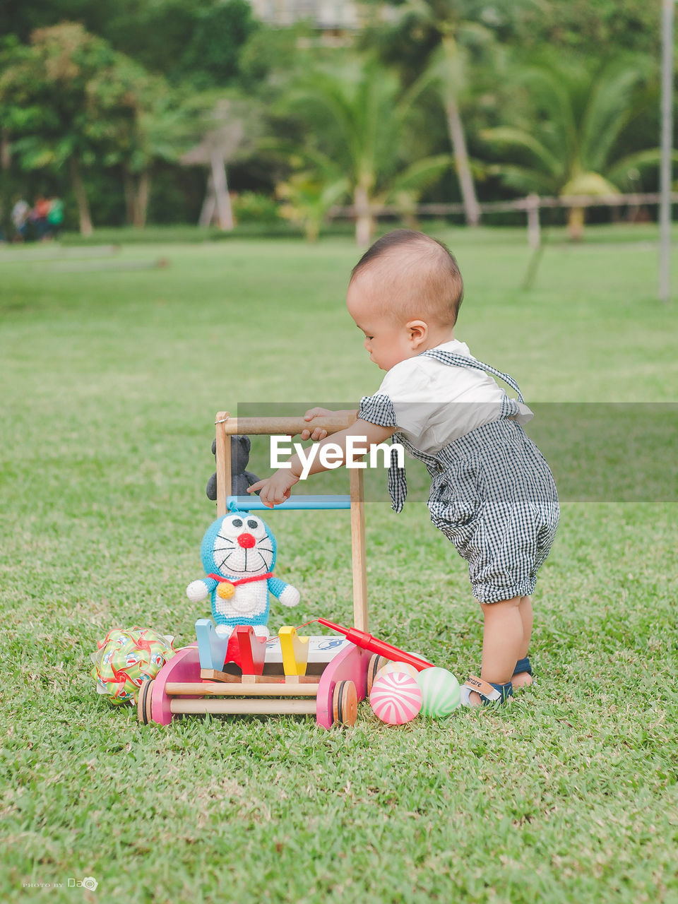 SIDE VIEW OF BOY PLAYING TOY ON GRASS