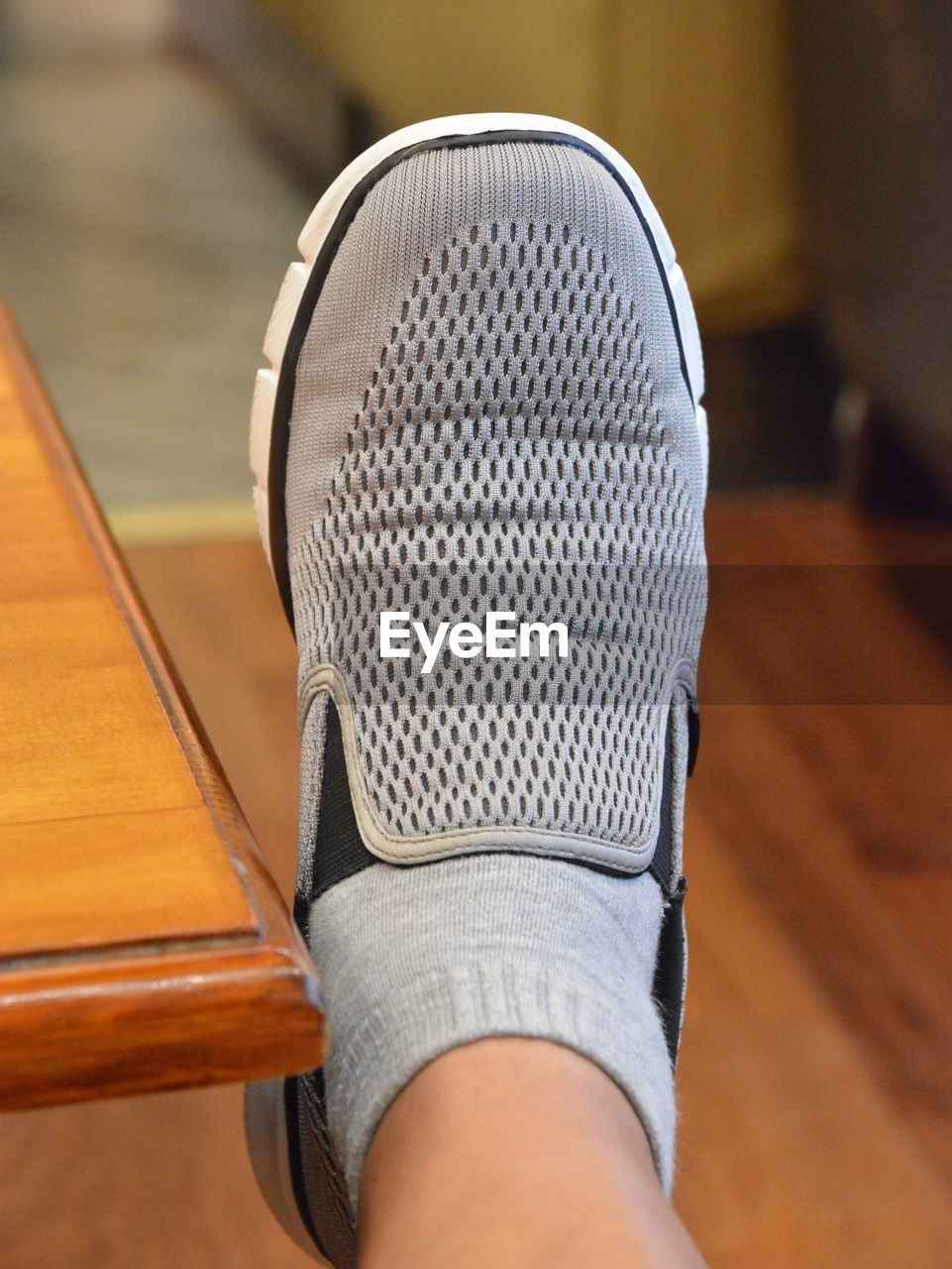 Low section of man wearing shoe at home