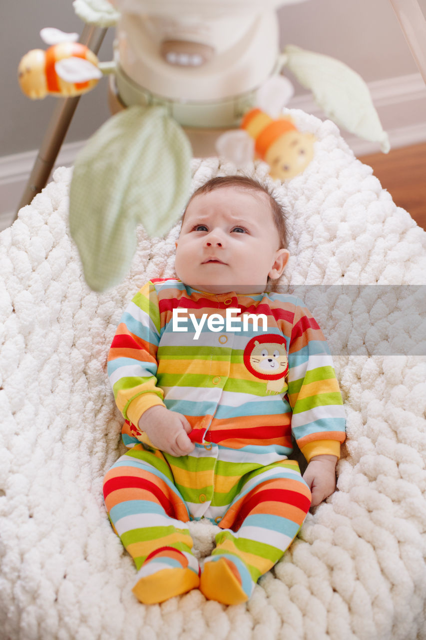 HIGH ANGLE VIEW OF CUTE BABY TOY ON BED