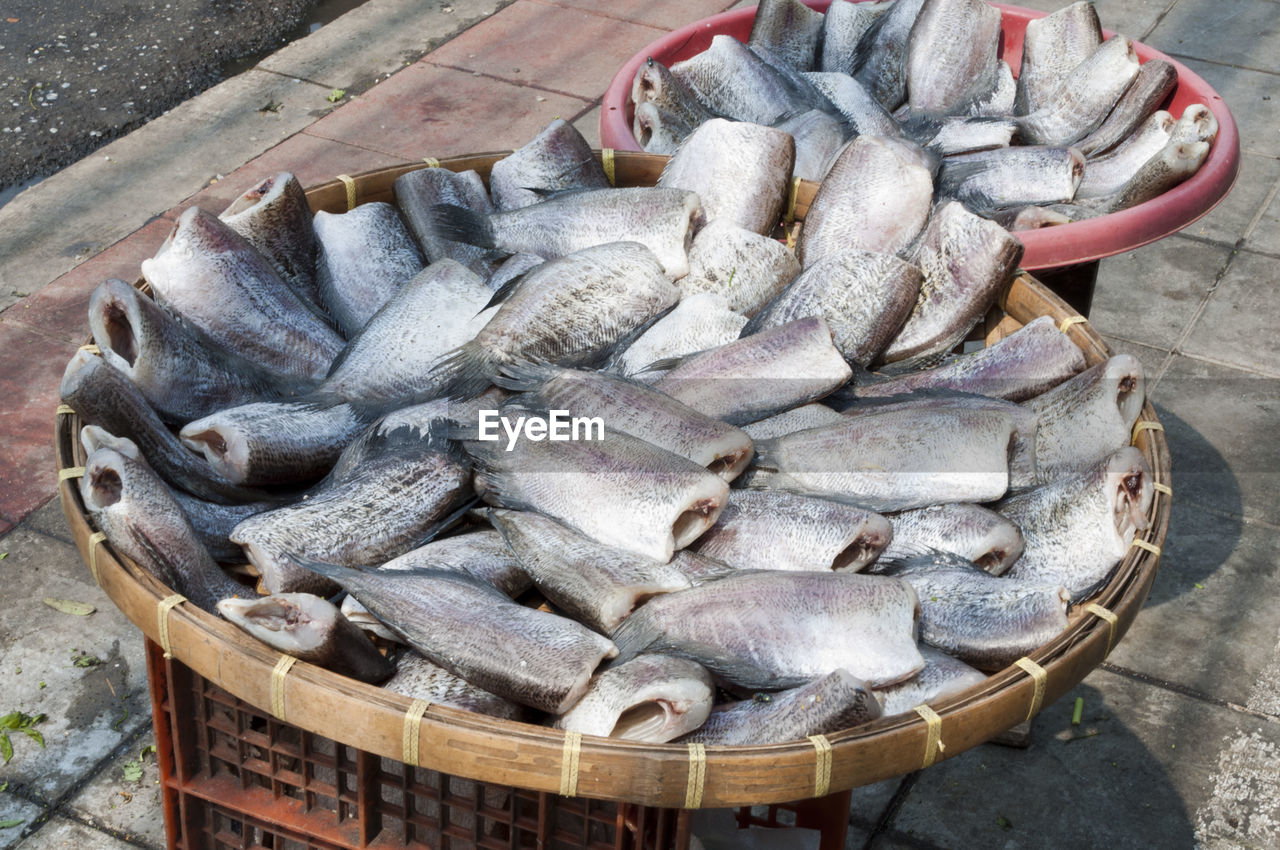 High angle view of dried fishes in container on crate for sale