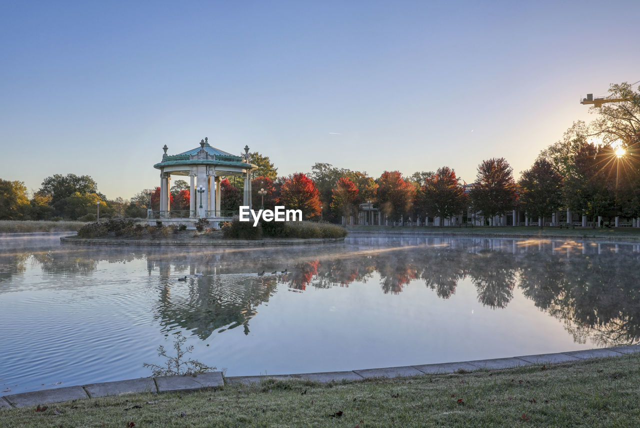 Built structure by lake against clear sky