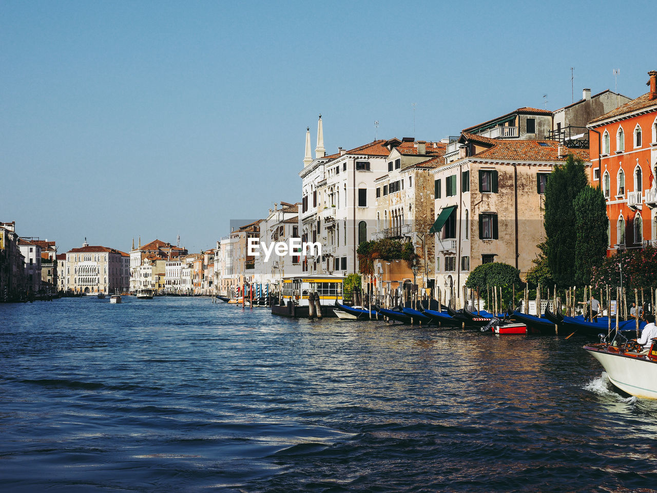 Canal against buildings in city on sunny day