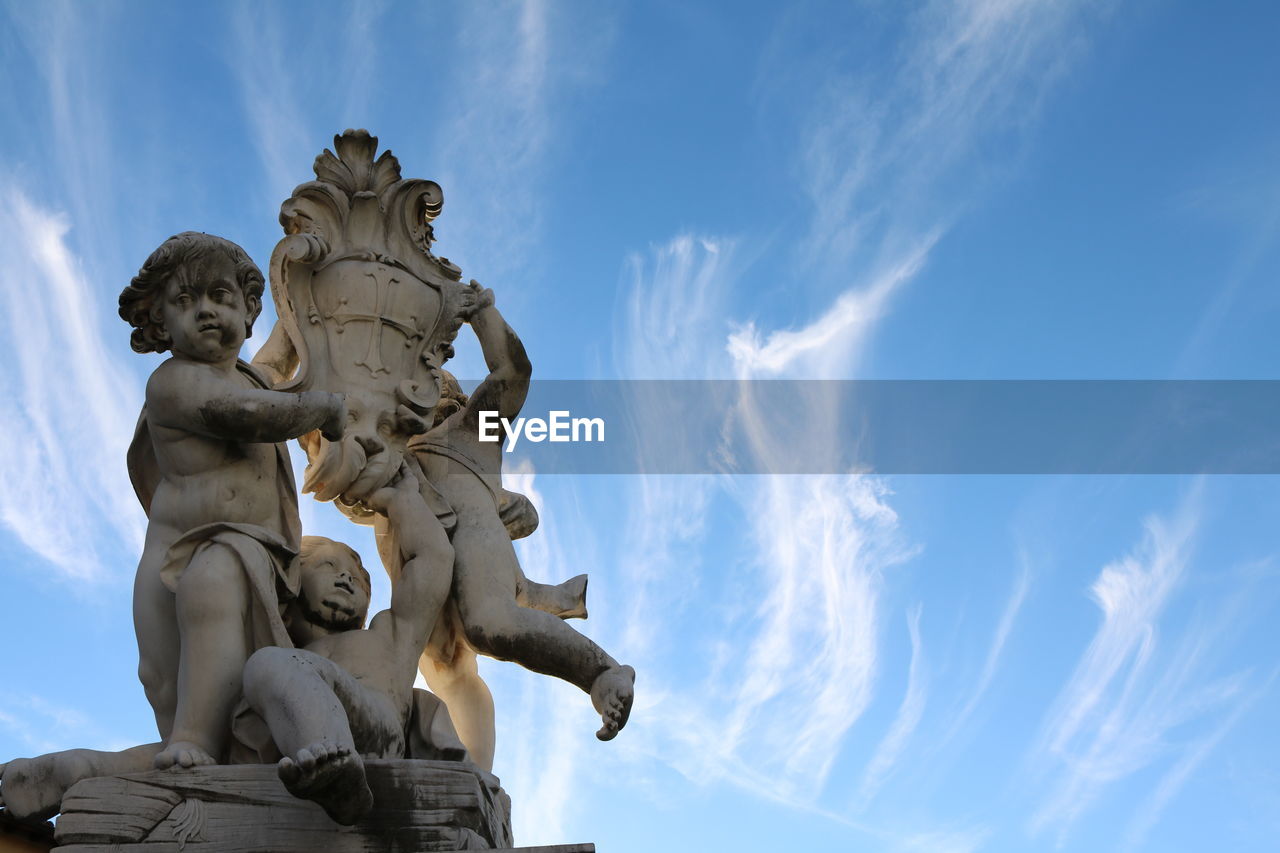 LOW ANGLE VIEW OF STATUES AGAINST SKY