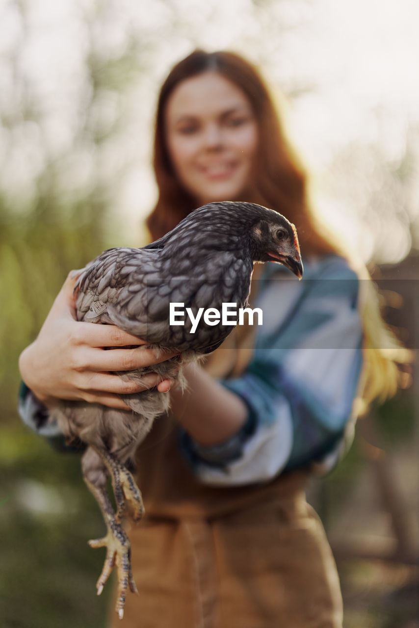 Portrait of woman holding bird feeder