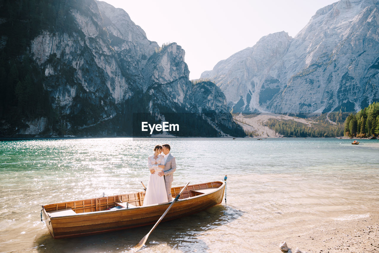 MAN ON BOAT AGAINST MOUNTAIN